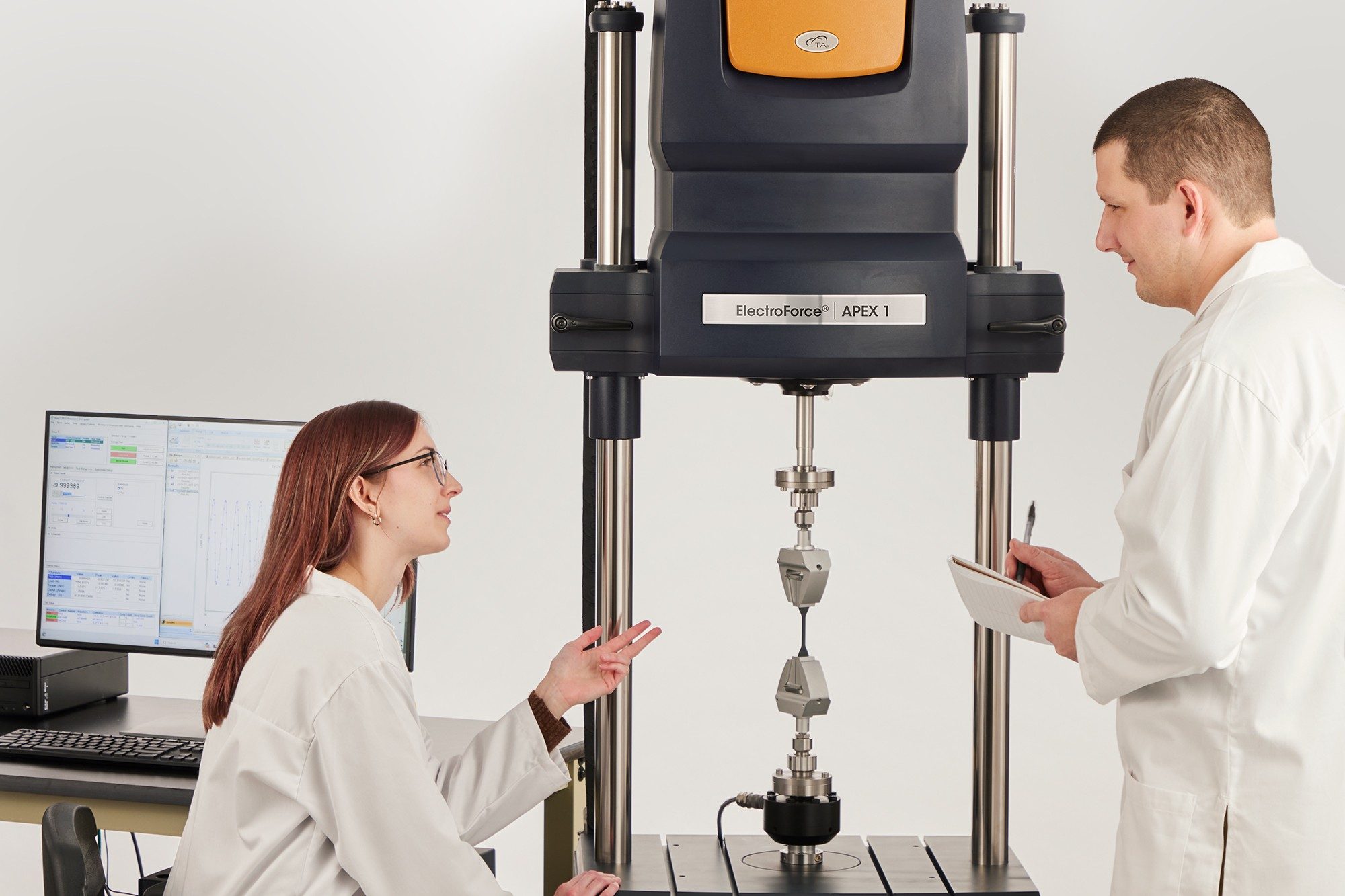 Two scientists using TA's ElectroForce Apex 1 system in laboratory