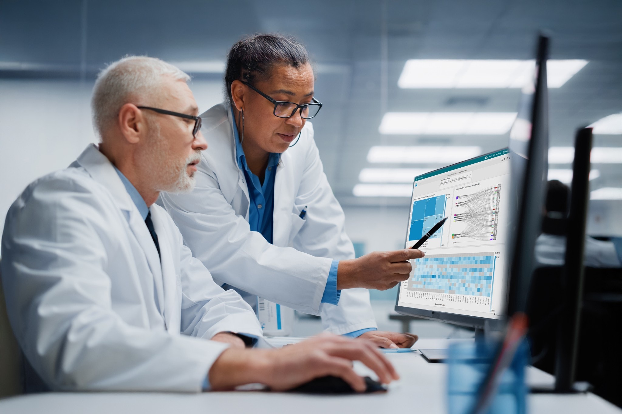 Two scientists using waters_connect Data Intelligence software on computer in laboratory