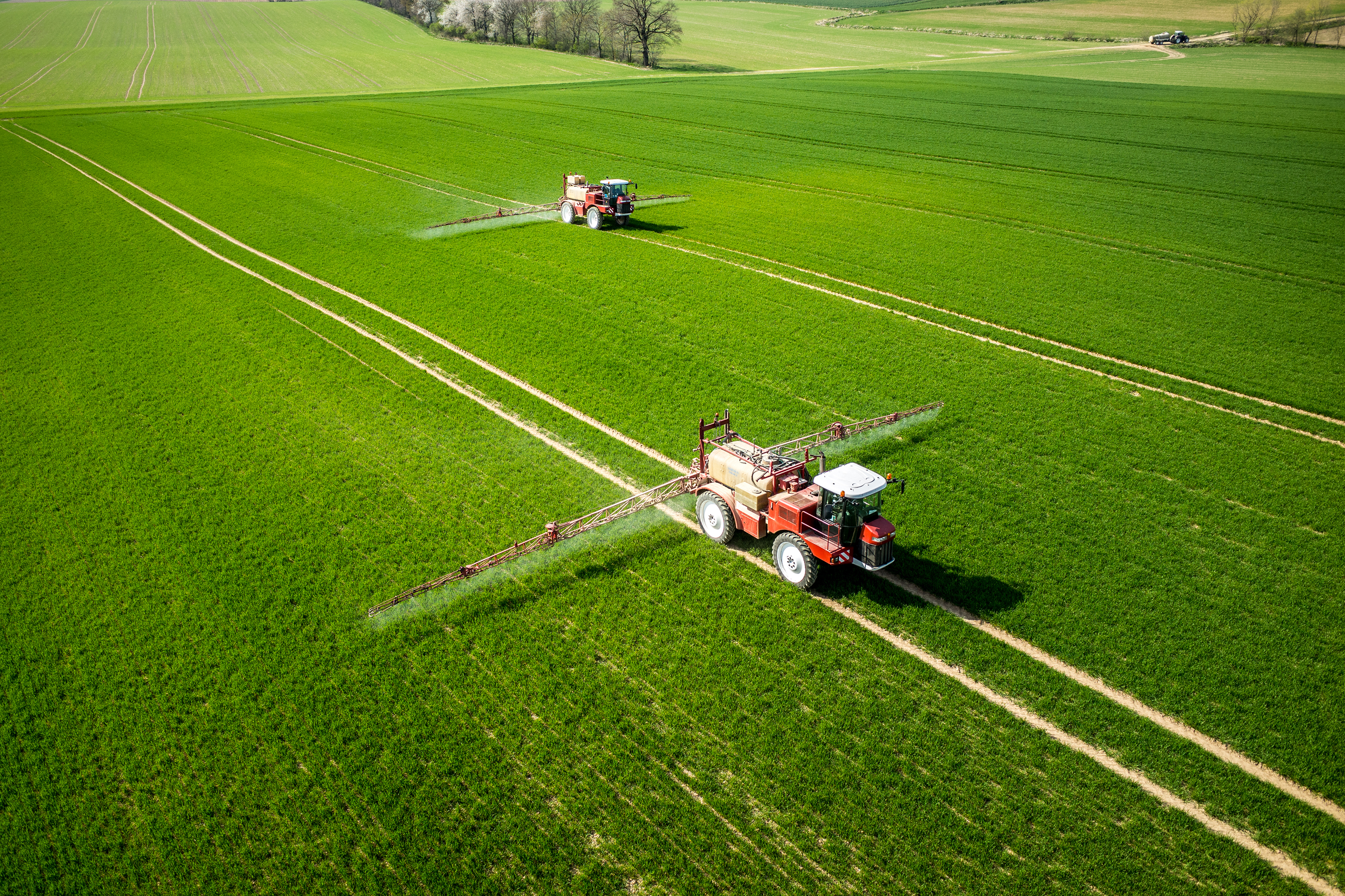 Aerial vew of tractor in field spraying pesticide