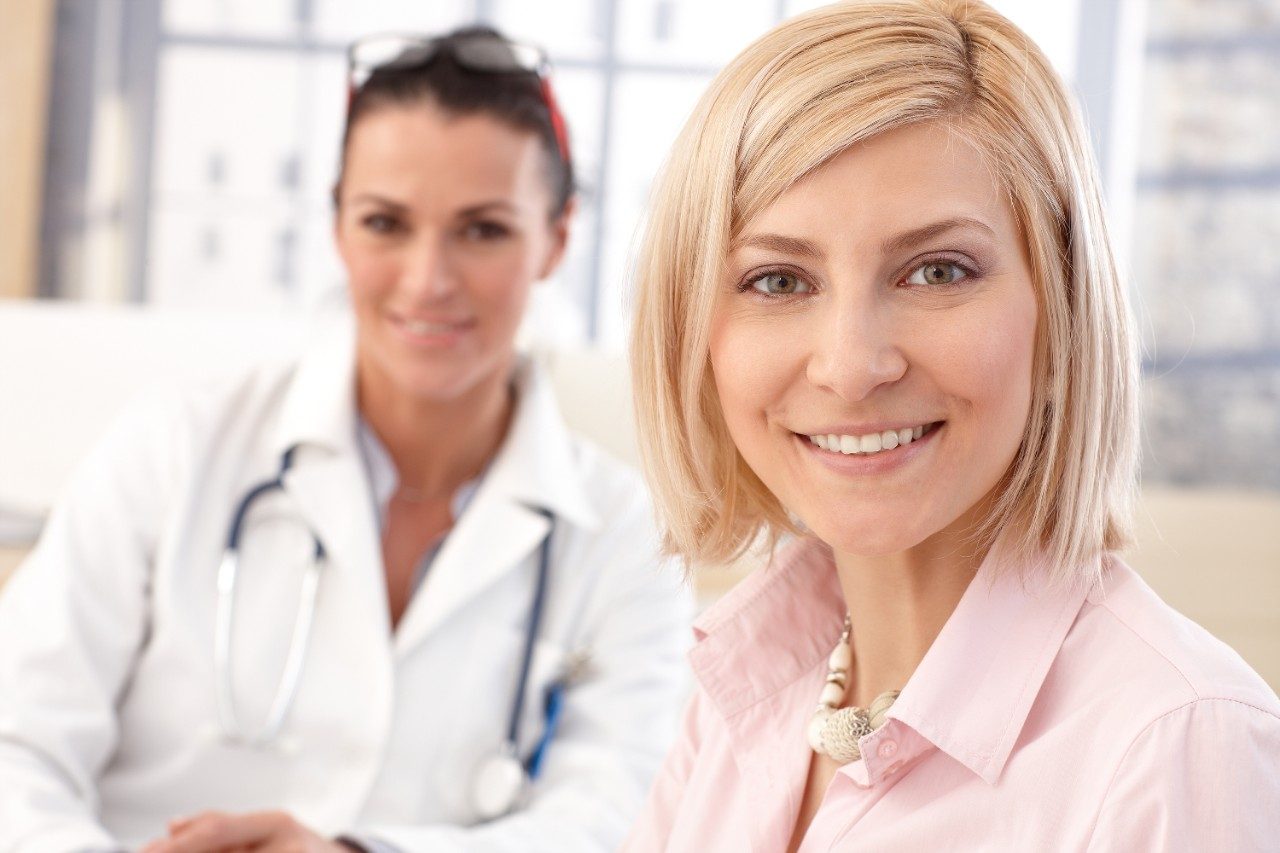 Happy blonde casual caucasian female patient at doctor's medical office