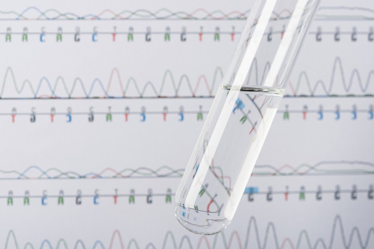 Test tube with transparent liquid and DNA chromatogram